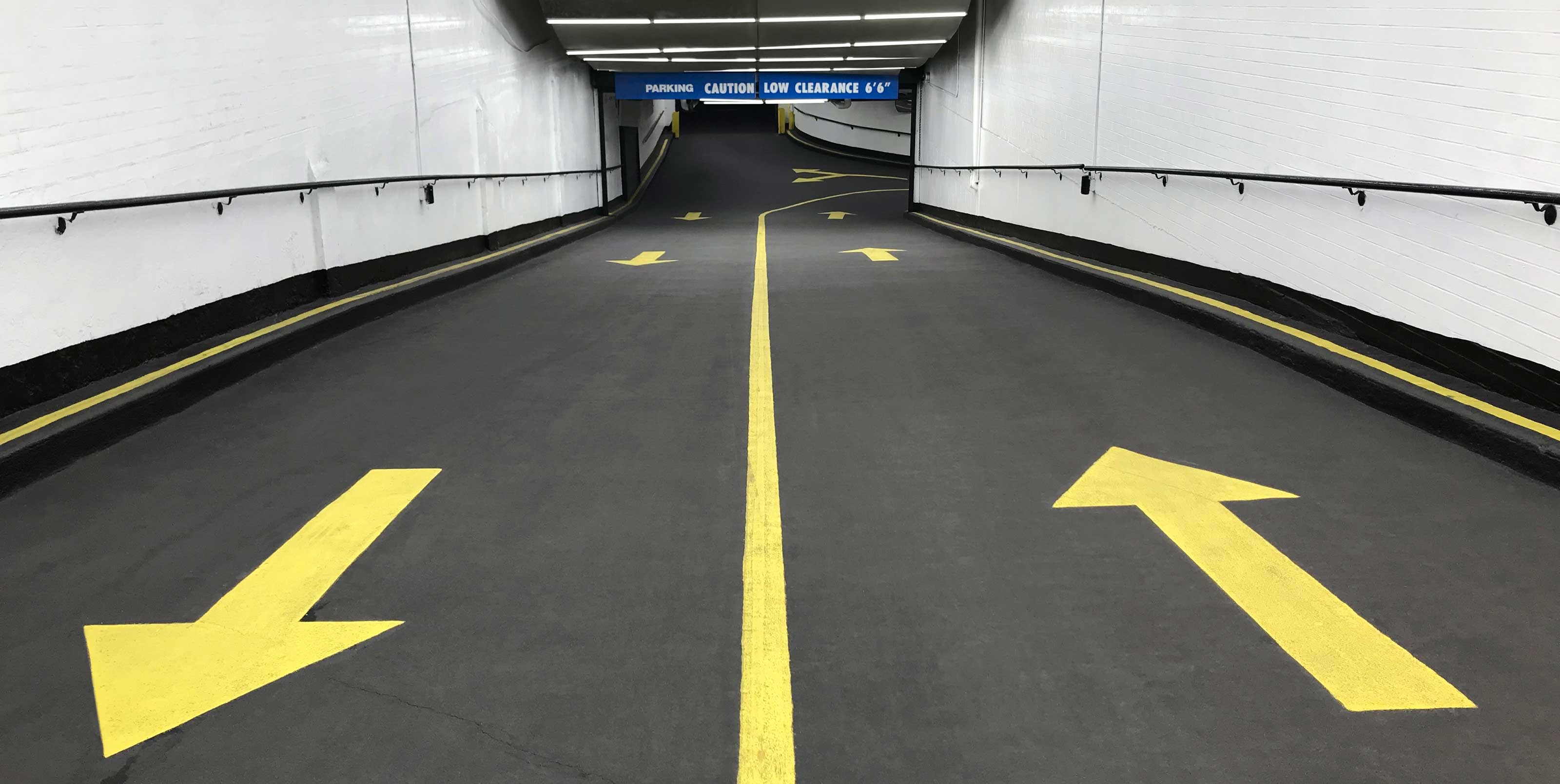 Underground parking entrance with yellow arrow markers Underground parking entrance with yellow arrow markers