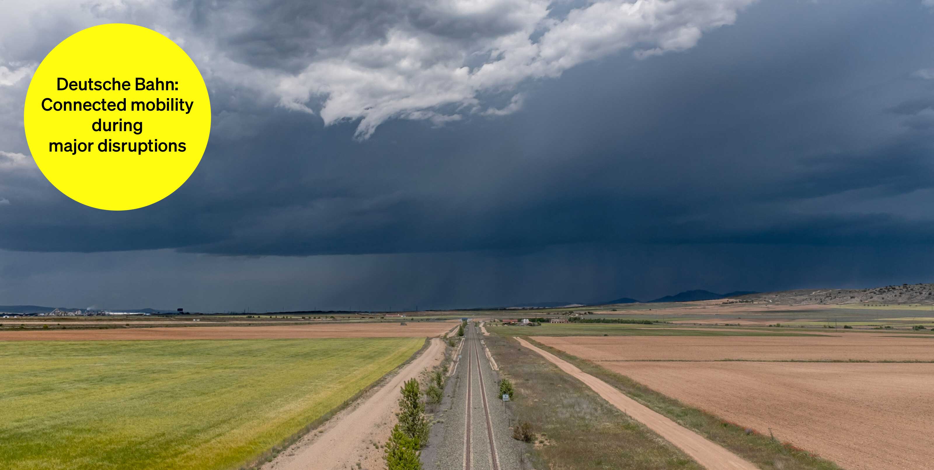 Railroad tracks between fields in cloudy weather - text module in round tile: Deutsche Bahn Mobilität vernetzt: Multimodal major disruption information Railroad tracks between fields in cloudy weather - text module in round tile: Deutsche Bahn Mobilität vernetzt: Multimodal major disruption information